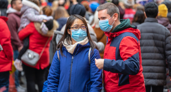 Man and woman in a crowd wearing facemasks