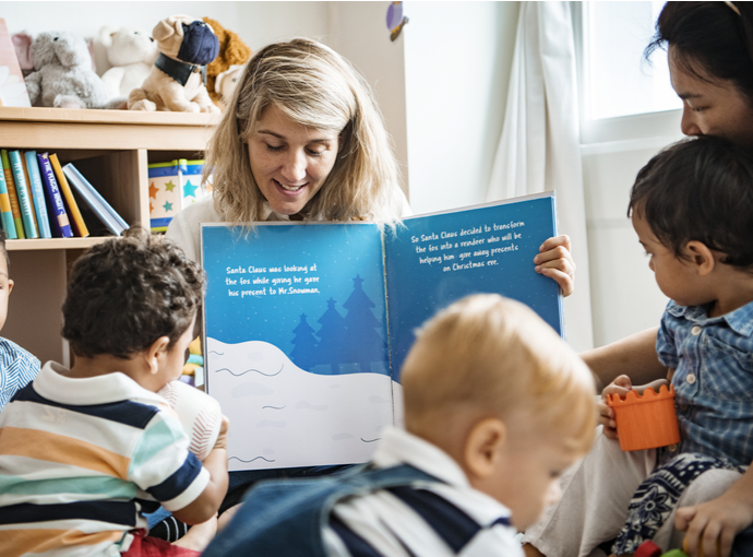 Early childhood teacher reading a book