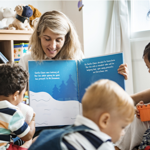 Early childhood teacher reading a book